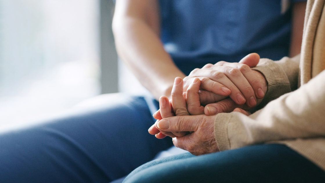 Caregiver and patient holding hands